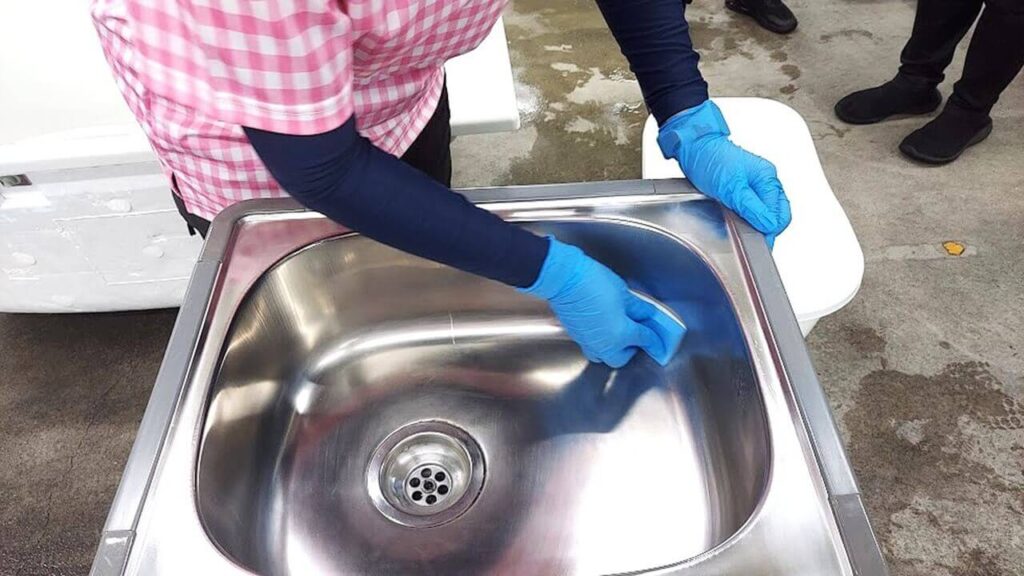 キッチンKeeperコーティング剤をシンクに丁寧に塗布している様子(草加市・越谷市対応)【お掃除どんちゃん】