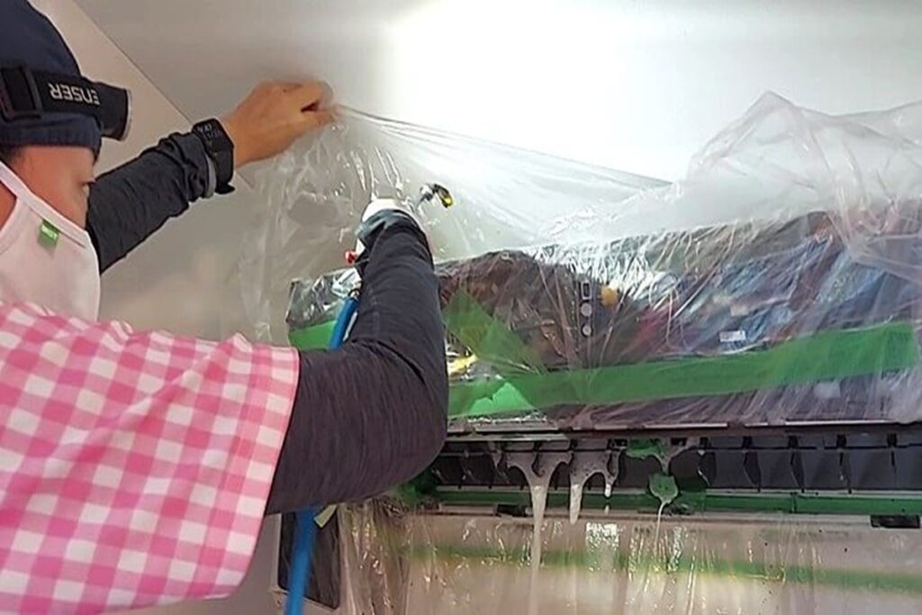 草加市でエアコン内部を高圧洗浄する作業風景