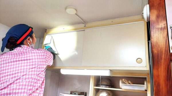 足立区の高齢者宅キッチン収納棚を家事代行・掃除代行サービスで洗浄している作業中の写真